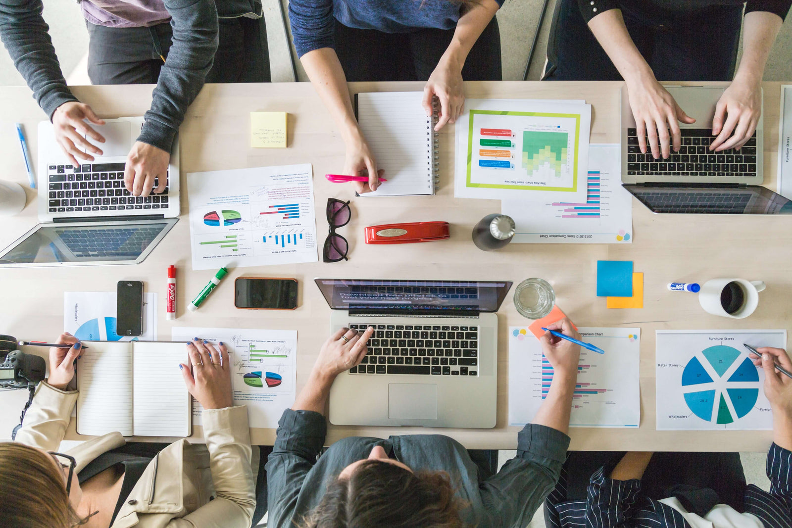 Top down of six people collaborating at a desk