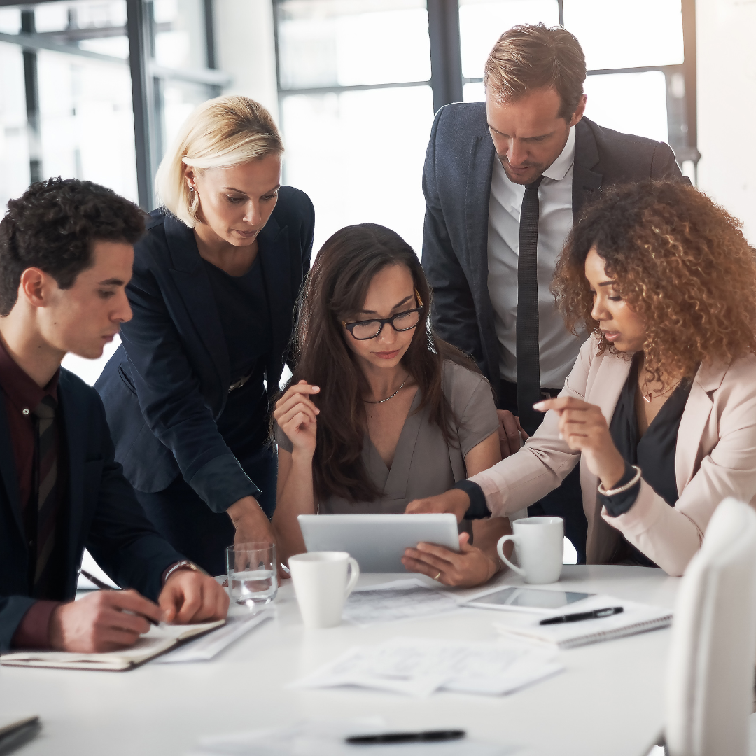 A team of people collaborating over an ipad