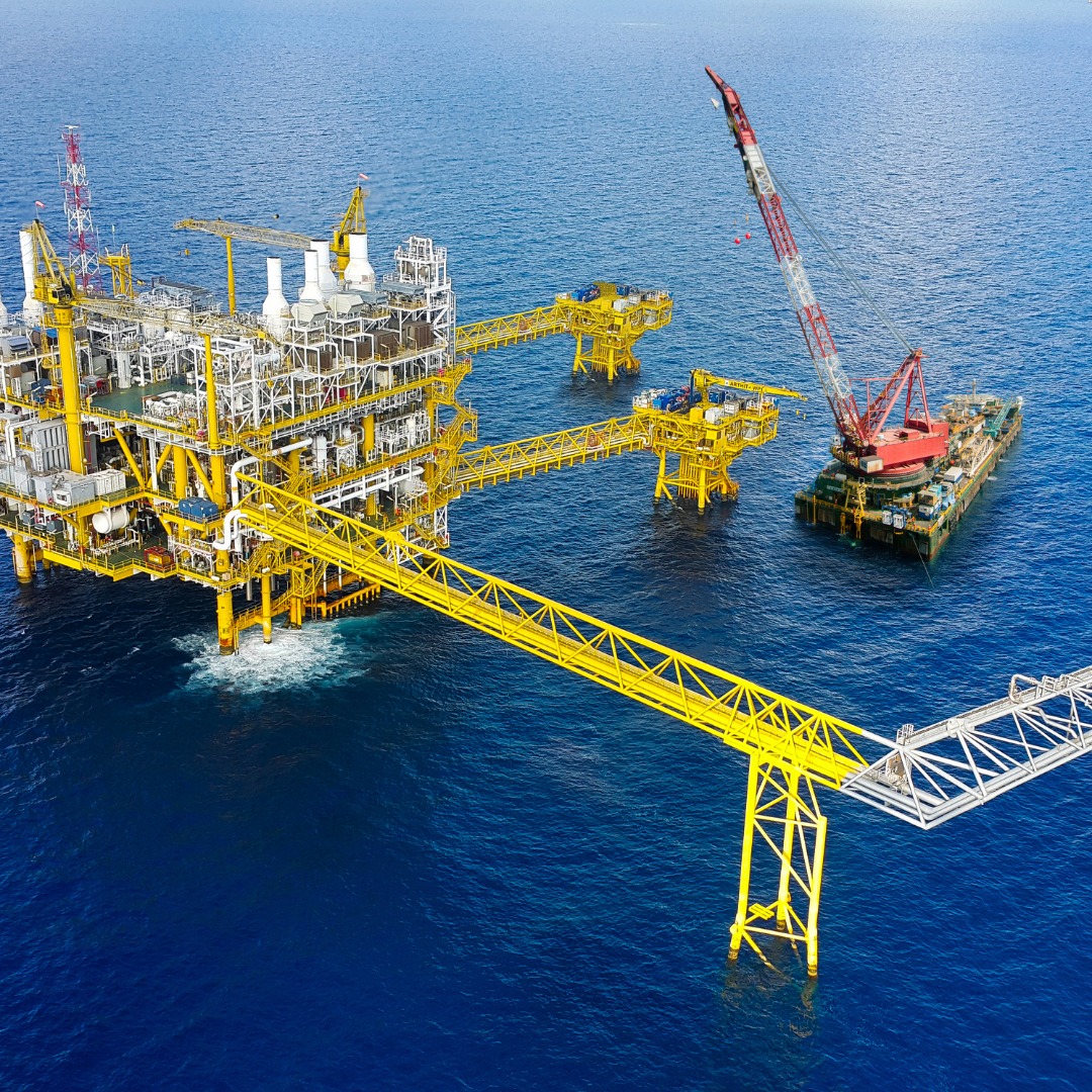 Aerial view of an offshore oil platform with a crane on a blue ocean background