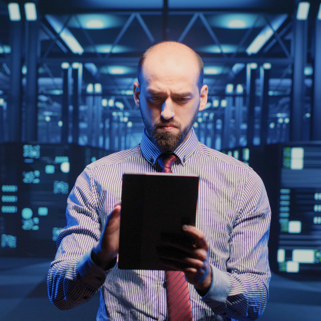 A person working on their tablet in an industrial server room