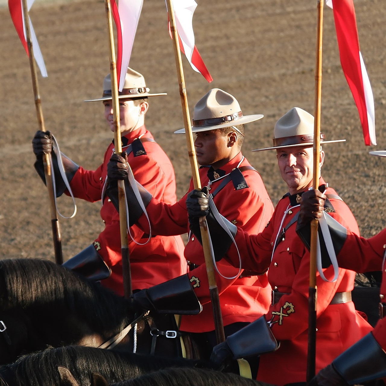 RCMP on horses holding Canadian flags
