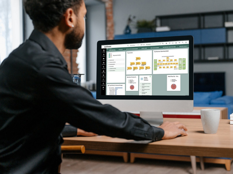 Man using a computer with a software interface on a desk in an office setting