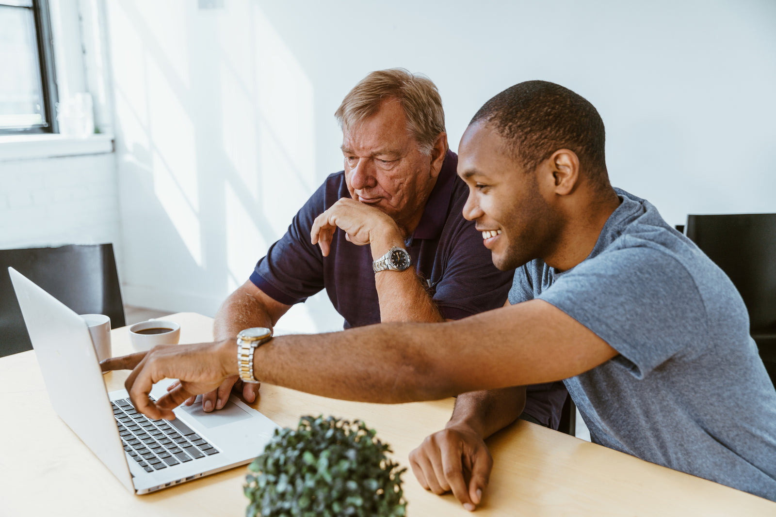 Man helping senior businessman on computer