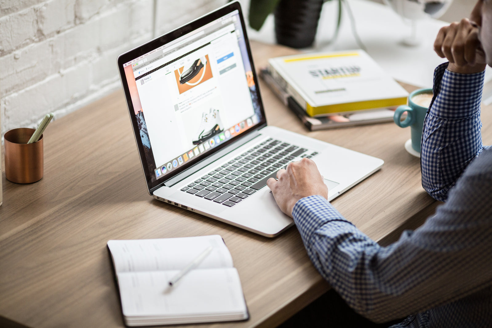 Person scrolling with web on a laptop at their desk