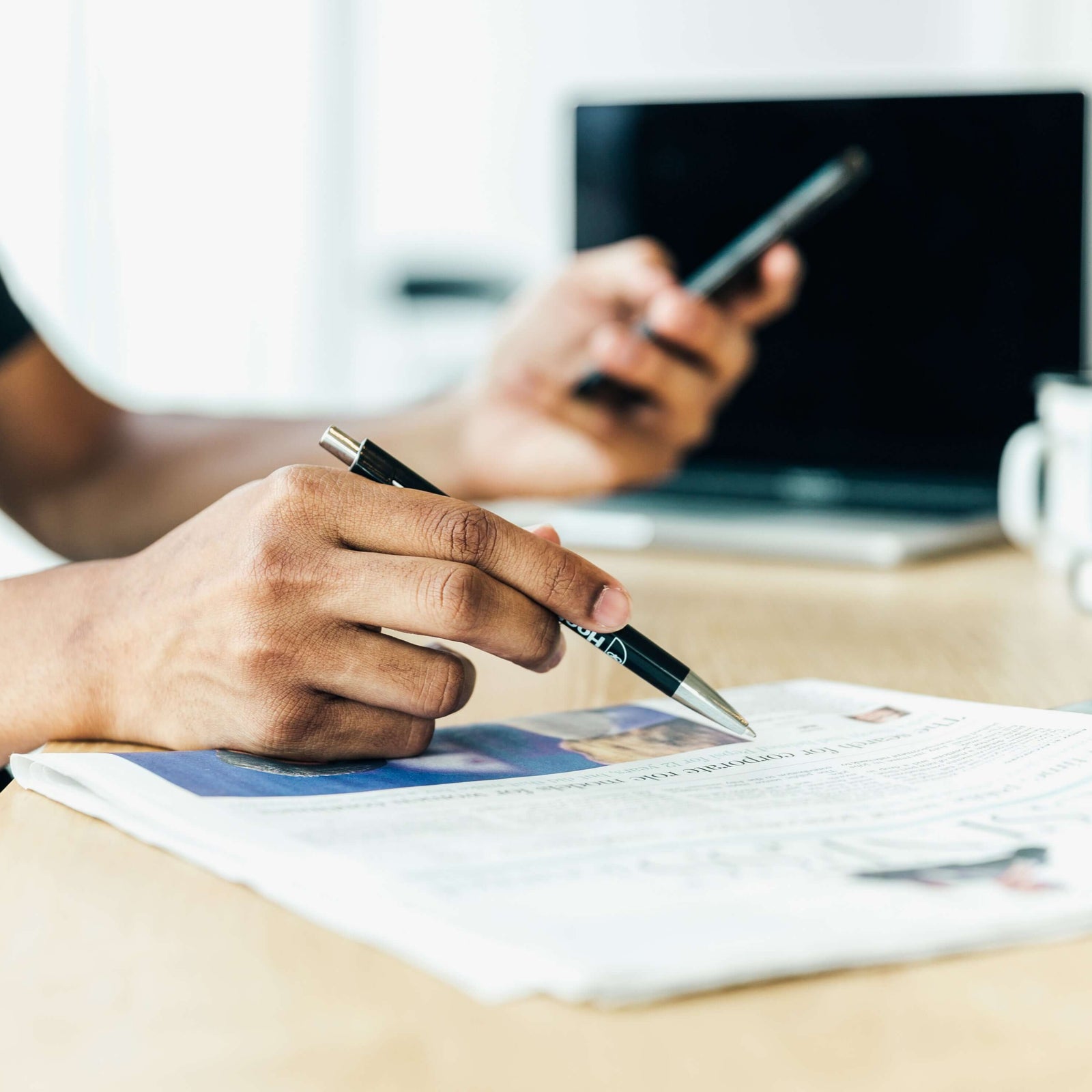 man at desk looking at his newspaper