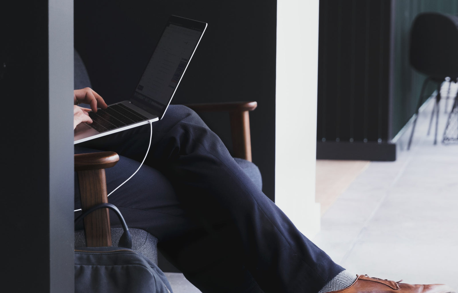 Man sitting on chair with laptop on lap